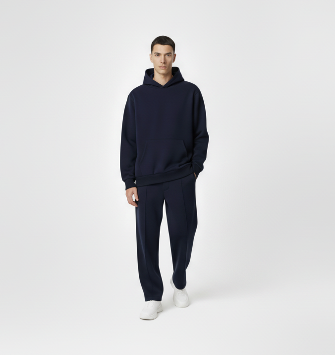Man wearing a navy blue hoodie and pants on a white background