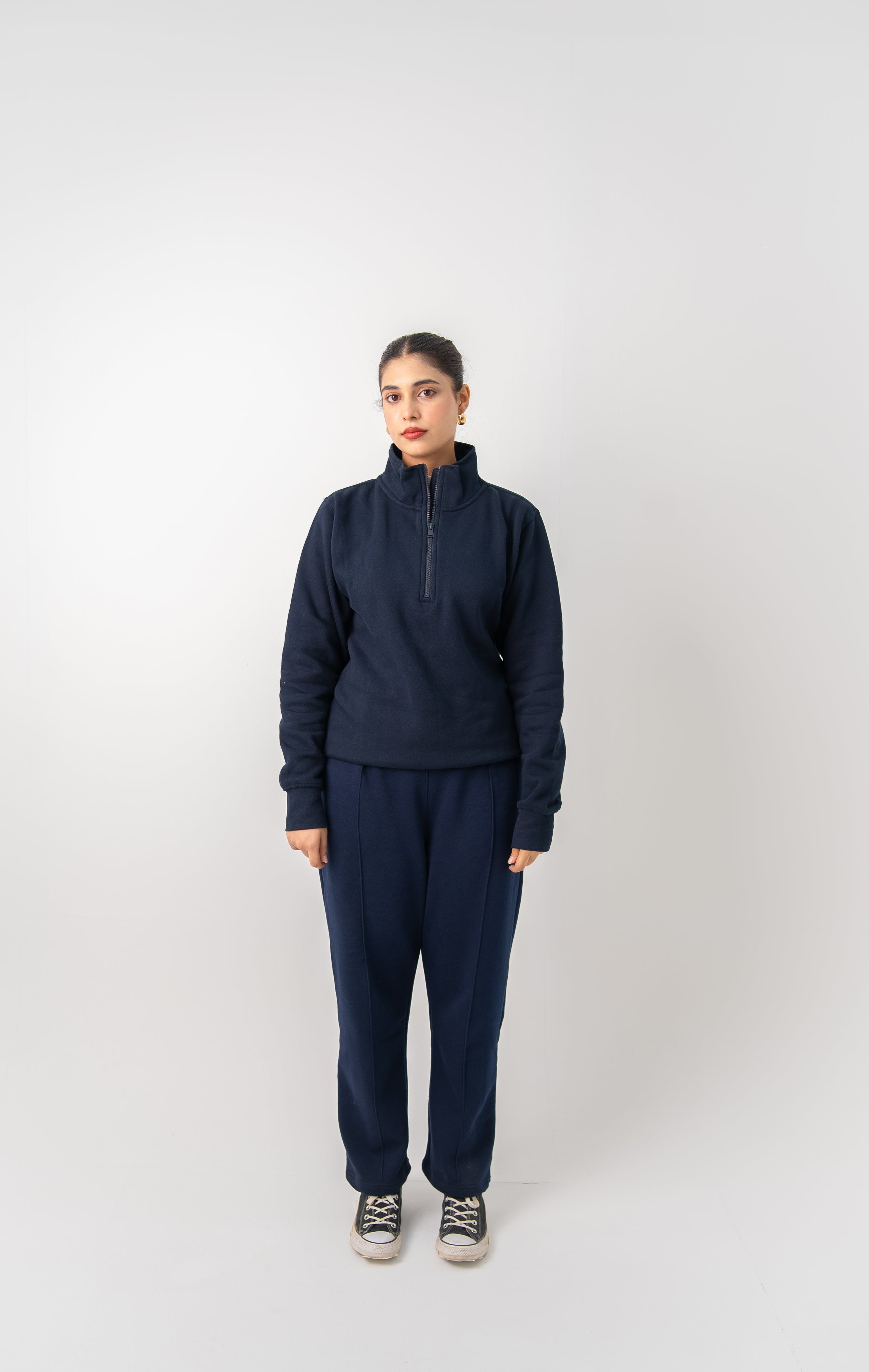 Person wearing a navy tracksuit on a white background