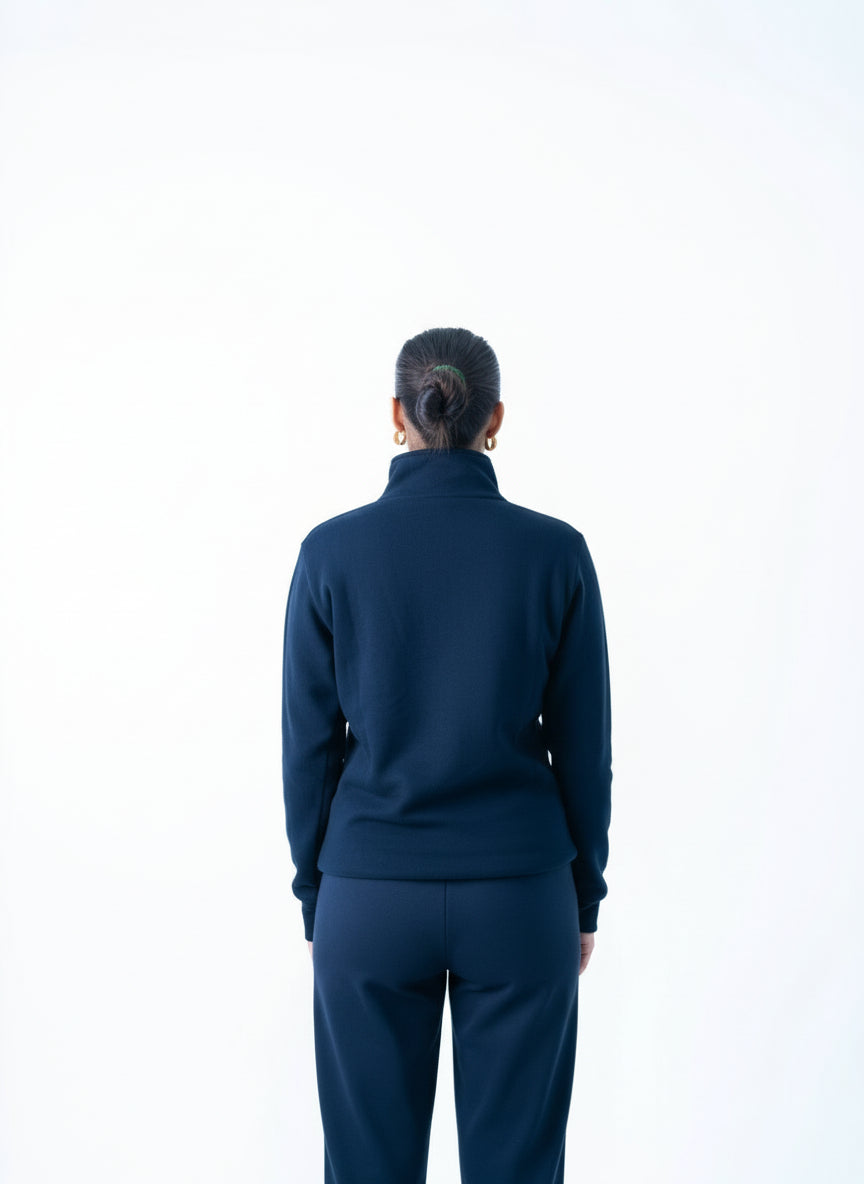 Person wearing a navy blue tracksuit on a white background