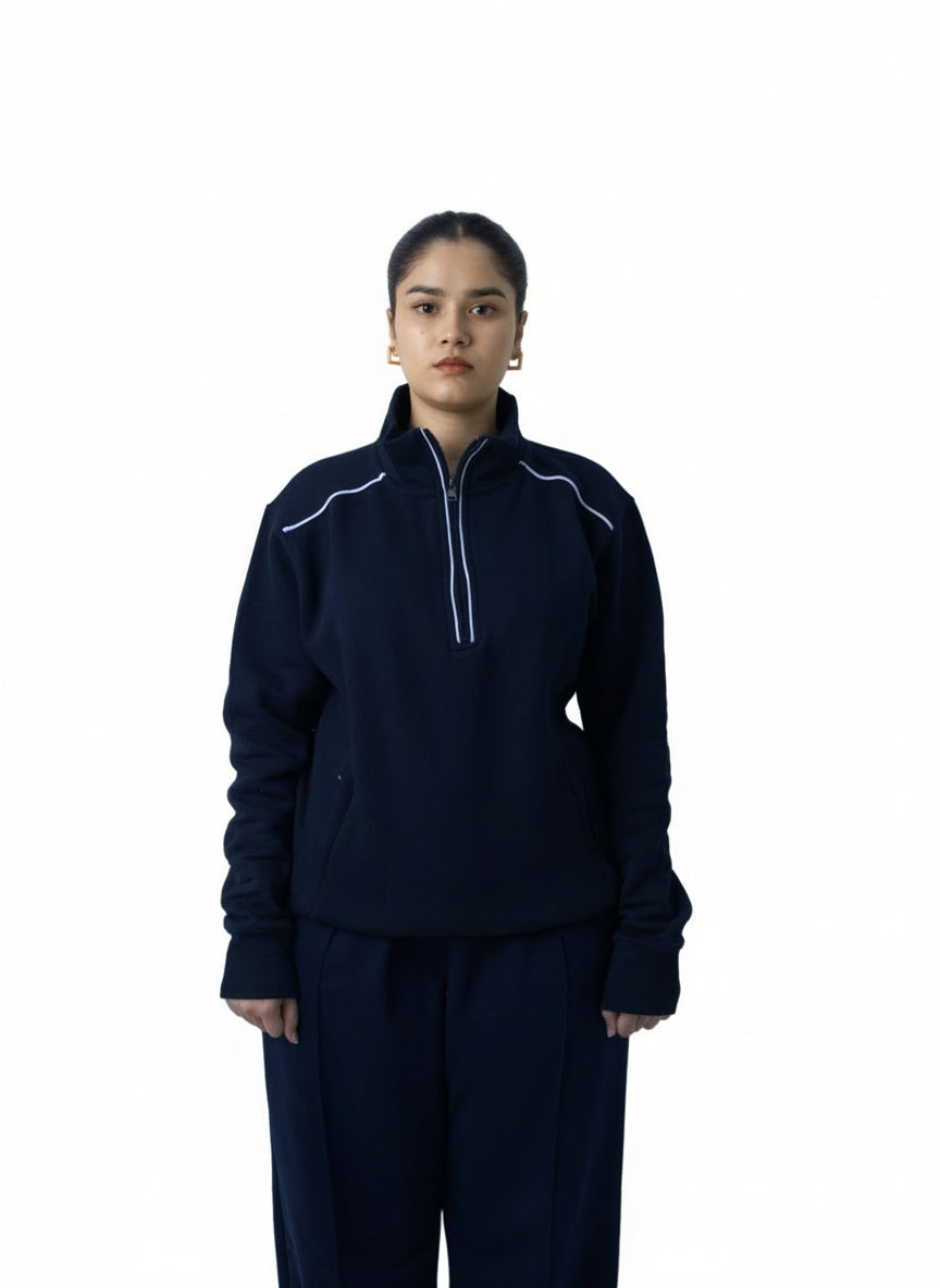 Person wearing a dark blue tracksuit with white accents on a white background
