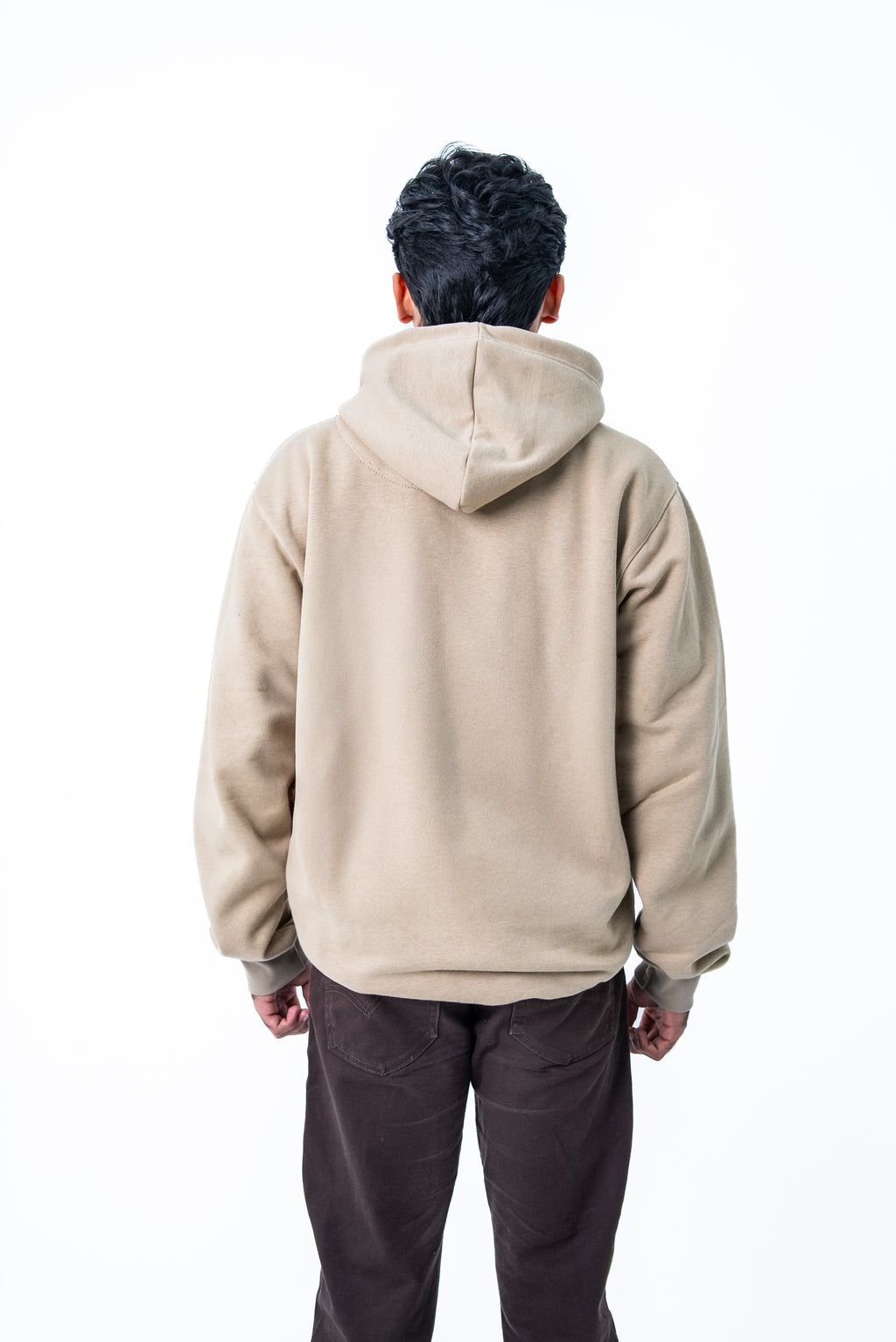 Person wearing a beige hoodie from behind on a white background