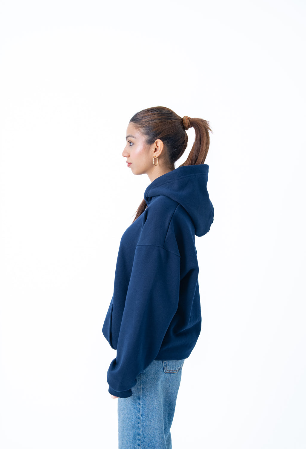 Person wearing a blue hoodie and jeans on a white background