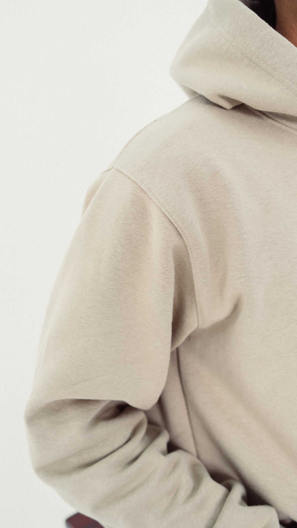 Beige hoodie worn by a person on a light gray background