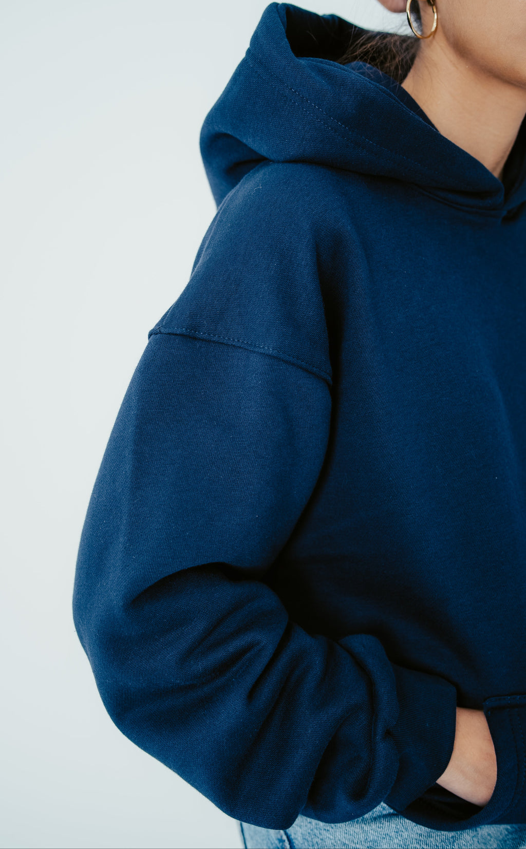 Person wearing a blue hoodie with a plain background